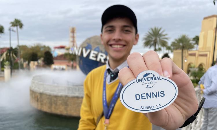 Graduating senior Dennis Velez holds his Universal Creative nametag outside of Universal Studios Orlando, where he worked as an intern.
