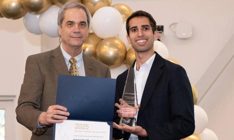 Gabe Ackall poses with Senior Associate Dean Doug Williams and the Tau Beta Pi award.