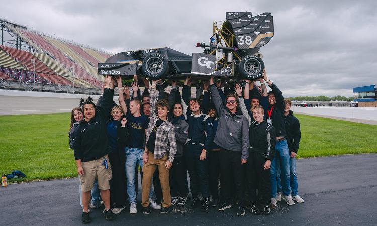 The Georgia Tech Motorsports team lifts their custom-built vehicle at the Michigan International Speedway. 