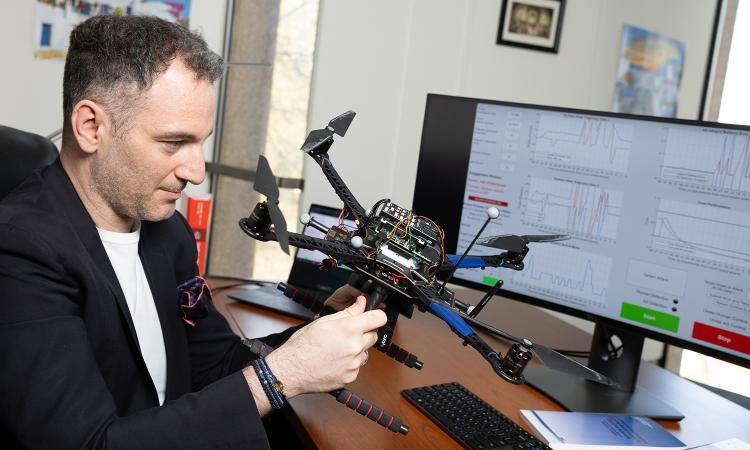 Kyriakos Vamvoudakis works with a drone at his desk.