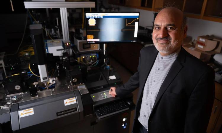 Ali Adibi with a 3D optical routing equipment in his lab.