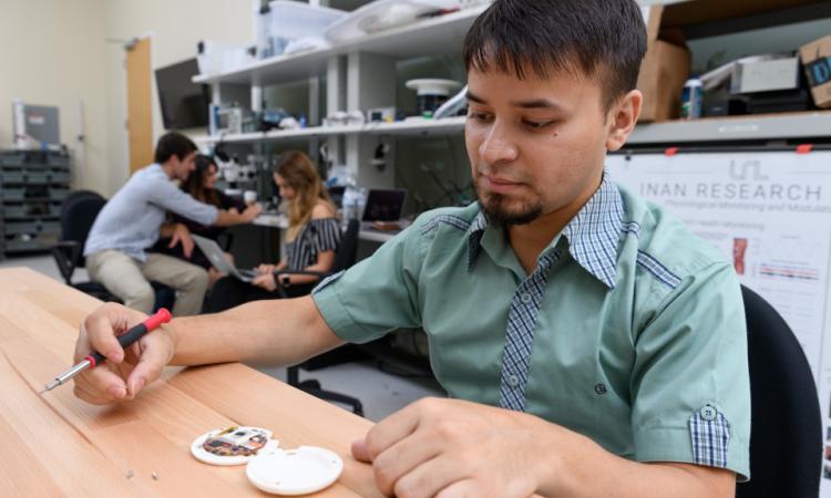 student looking at device on table