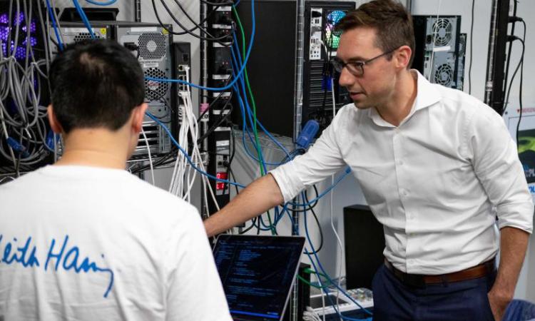 Researcher Brendan Saltaformaggio talks with a student in their cybersecurity lab.