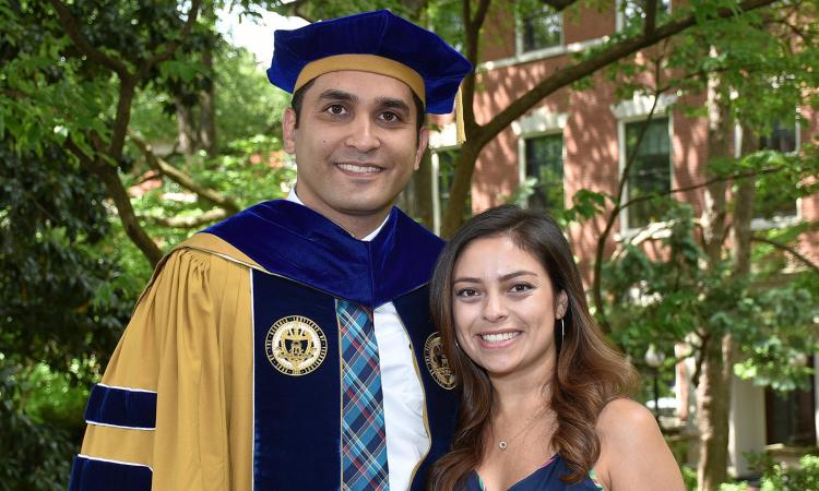 Ali Khosravani poses in his Ph.D. regalia with his future wife, Natalia.