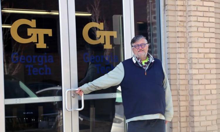 David Frost stands at the glass doors of the new home for the Geosynthetic Institute, which feature a large Georgia Tech logo.