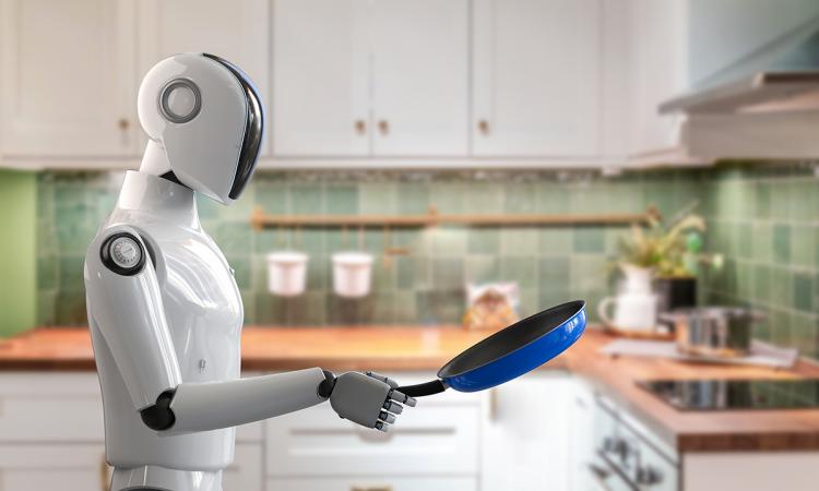 A humanoid robot holds a pan in a kitchen.