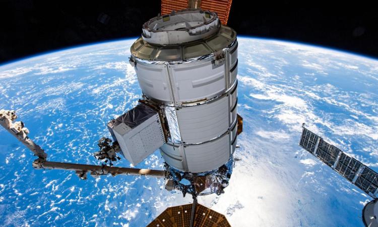 Northrop Grumman's Cygnus space freighter is pictured in the grip of the Canadarm2 robotic arm at the International Space Station with the Earth below.