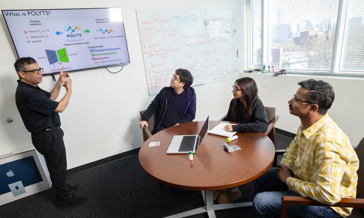 Rampi Ramprasad and three members of his research team discuss their AI model for generative polymer design in his office.