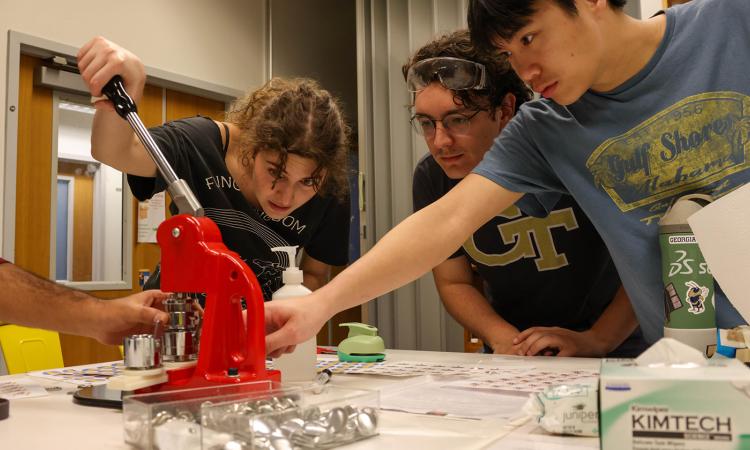 A team of students works on a challenge in The MILL makerspace during the Helluva Makerspace Race.