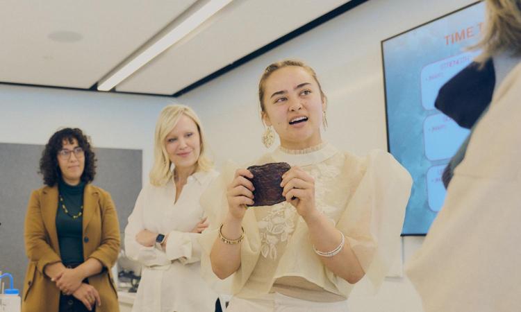 Mya Love Griesbaum shows off a textile sample created by using fungi to degrade discarded synthetic fabric.