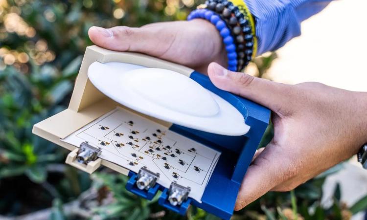 A close‑up of a device with an array of tiny antenna elements behind a lens, each modulating reflected wireless signals to power high‑speed communication with minimal energy.