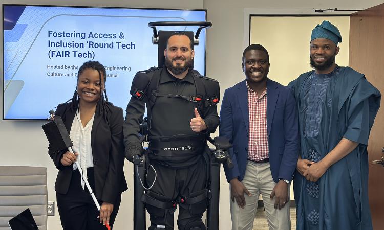 Competition winners pose after their presentations. Janiya Richardson holds a smart cane and Ignacio Montoya stands in a walking exoskeleton next to Ayomide Samson Oluwajoba and Taofik Ahmed Suleiman.