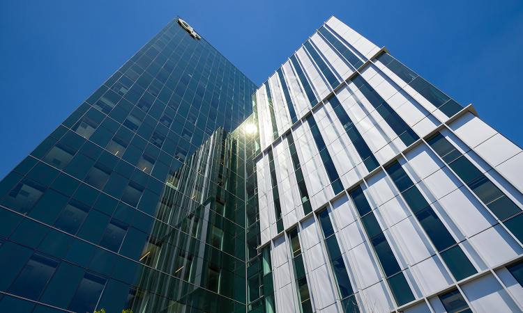 looking up at a skyscraper with the Georgia Tech logo against a blue sky