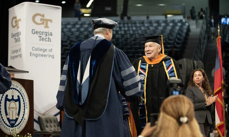 Kenneth Grundborg shakes Interim Dean Doug Williams' hand as he walks across the stage at the Engineering Master's Graduation Celebration.