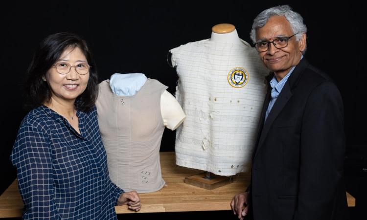woman and man stand in front of two shirts on mannequins