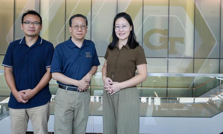 Researchers Xiao Liu, Yu Ding, and Quan Zeng pose in the George Tower lobby.