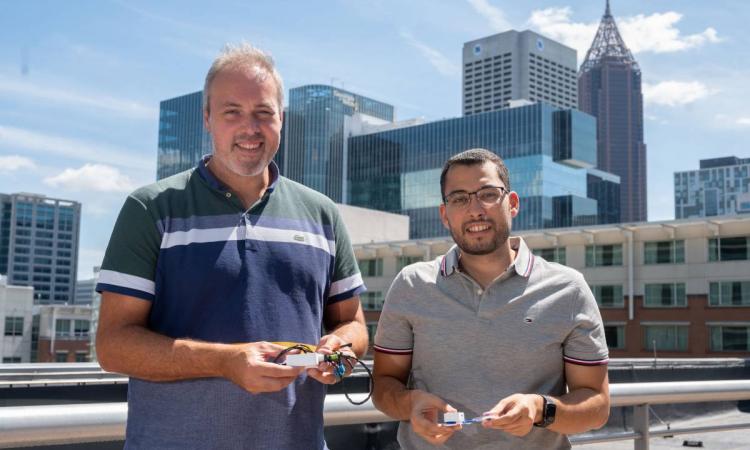 Samer Mabrouk and Omer Inan hold prototypes of their device