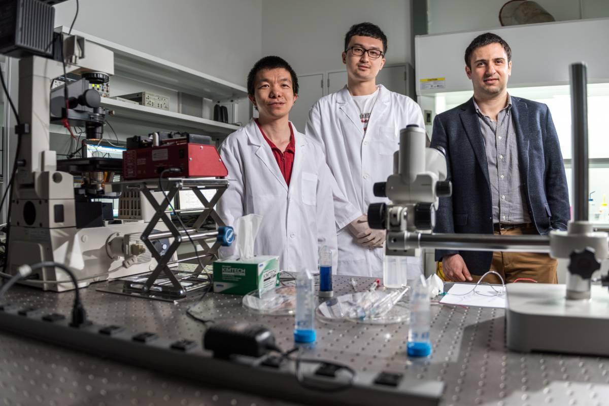 Fatih Sarioglu (right) working with two graduate students in the lab.