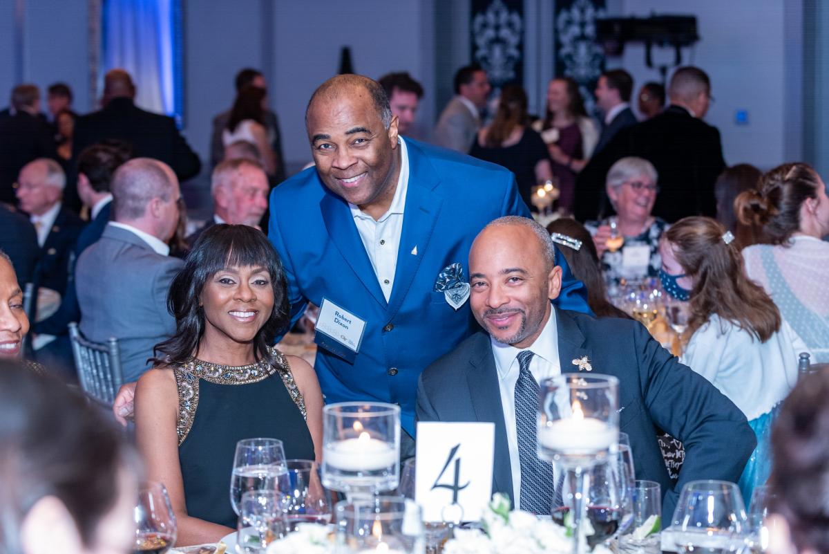 Three people smiling at camera in ballroom