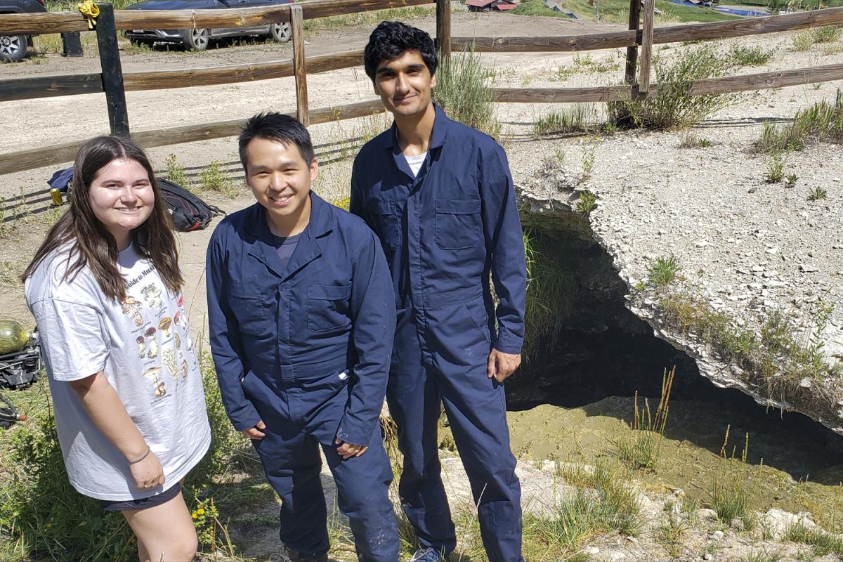 Students Emily Kaufman, Harry Tuazon, and Darshan Chudasama at the cave entrance