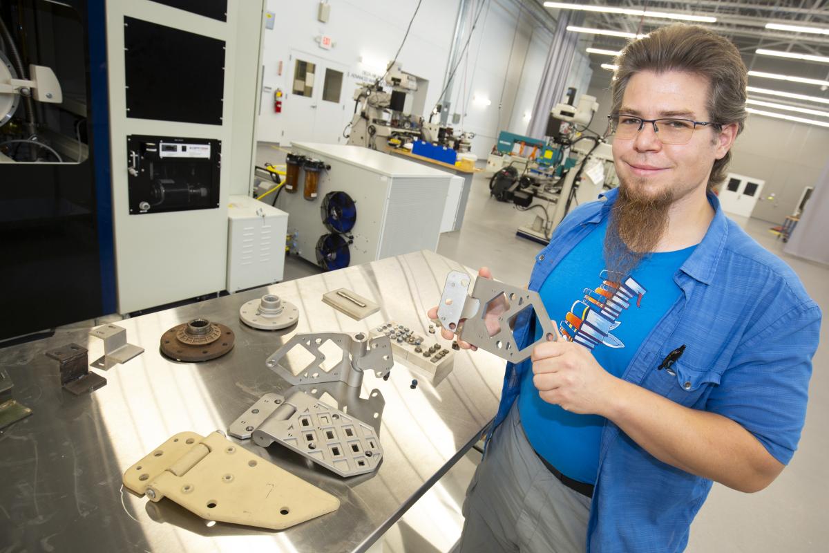 A person in the Advanced Manufacturing Pilot Facility with manufactured products