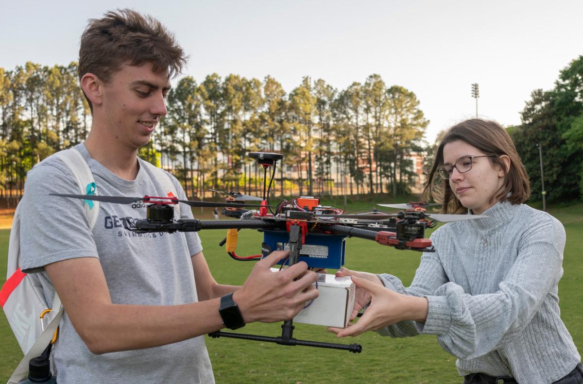 Two students work with a delivery drone 