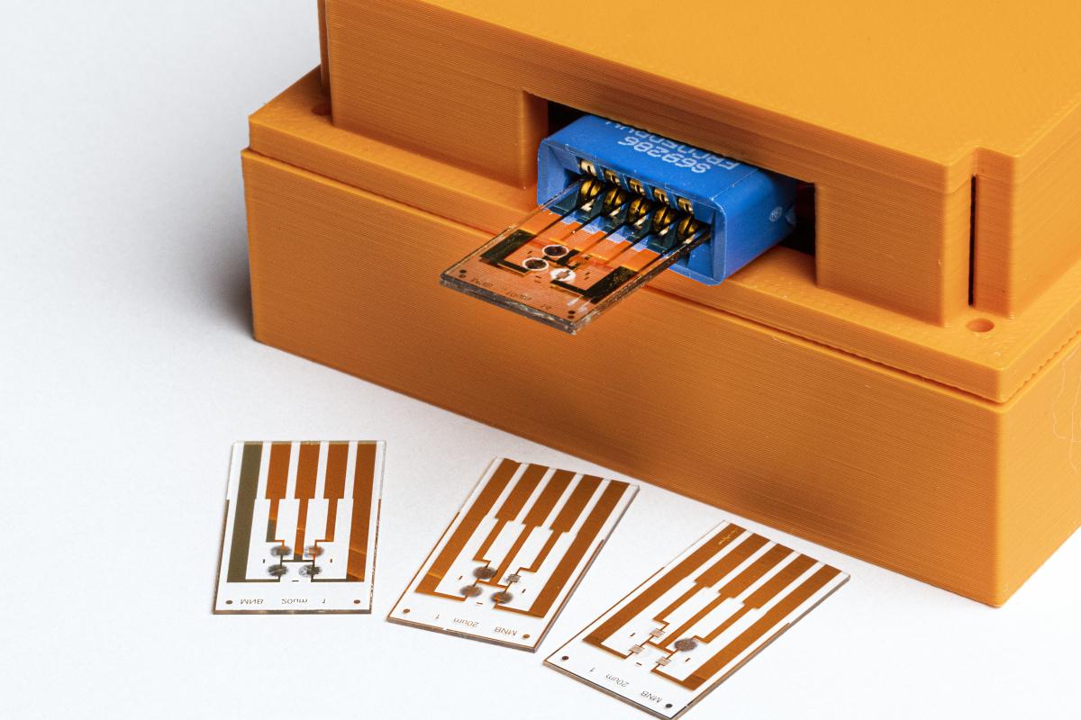 a microchip shown in a multimeter, with additional chips in front