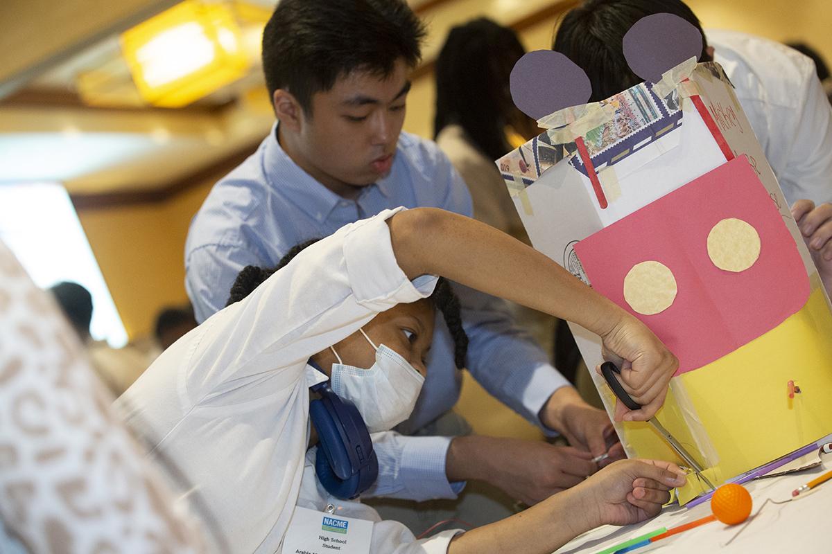 Metro Atlanta high school students work on their cardboard funhouse design during an engineering design challenge at the NACME national conference in Buckhead.