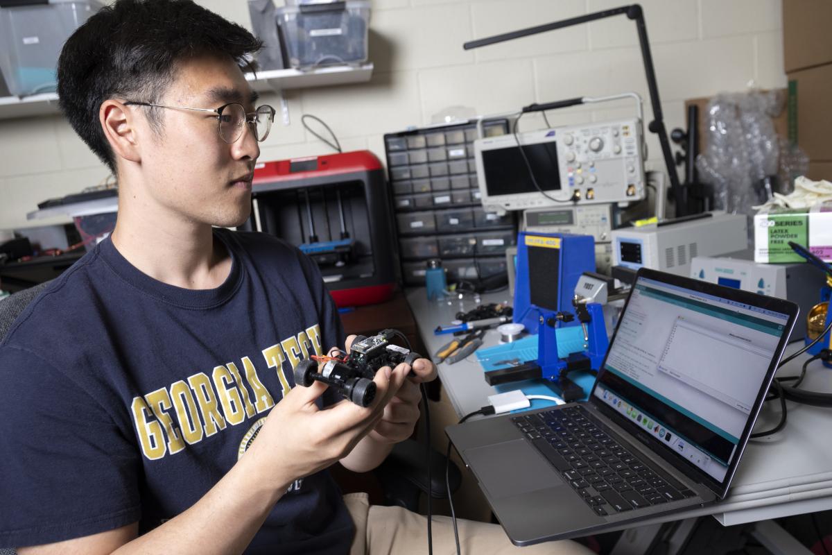 A VIP student works with a scale model car at a computer