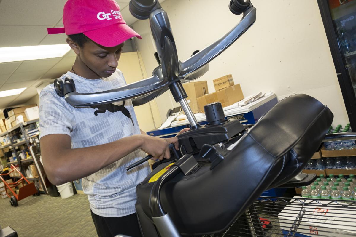 a student repairs an office chair