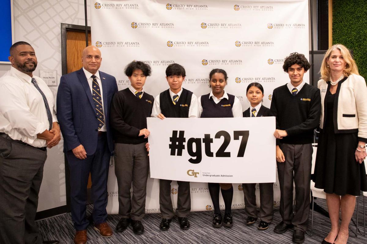 Cristo Rey students and staff with ME Chair Devesh Ranjan, holding a sign #gt27