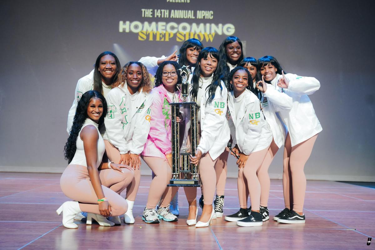 A group of people on stage with a trophy