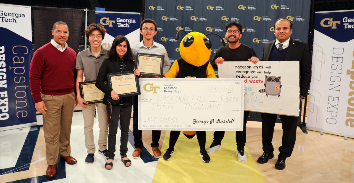 the winning team poses with Buzz and an oversized check