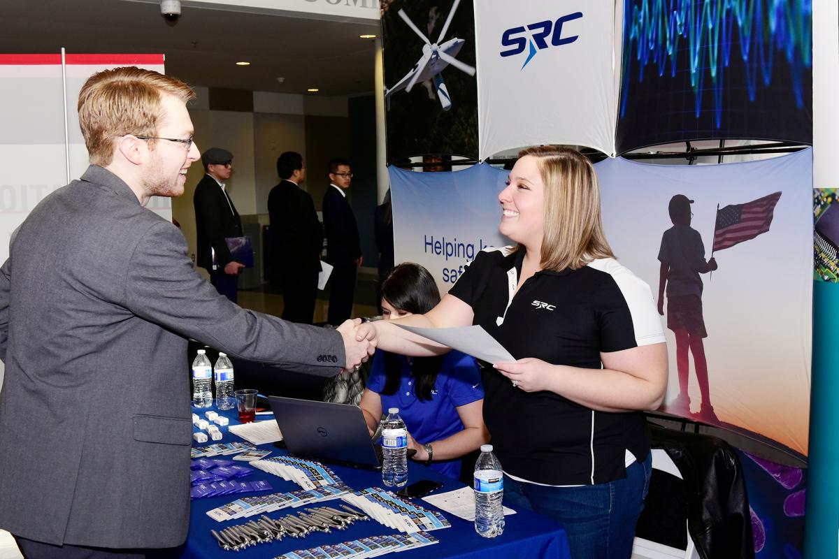 A student and company rep shake hands at the ECE Career Fair