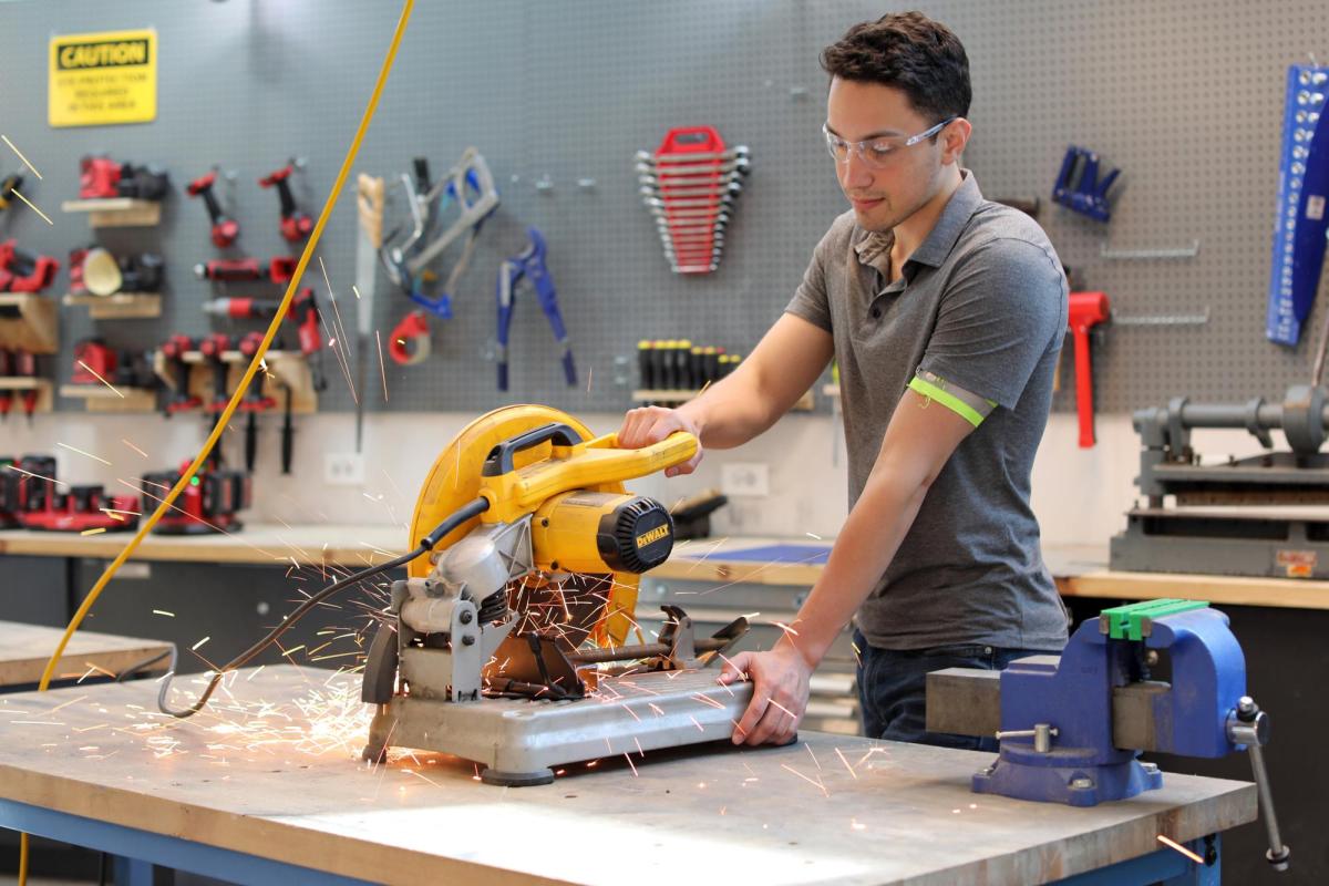 A student using a saw in the Flowers Invention Studio
