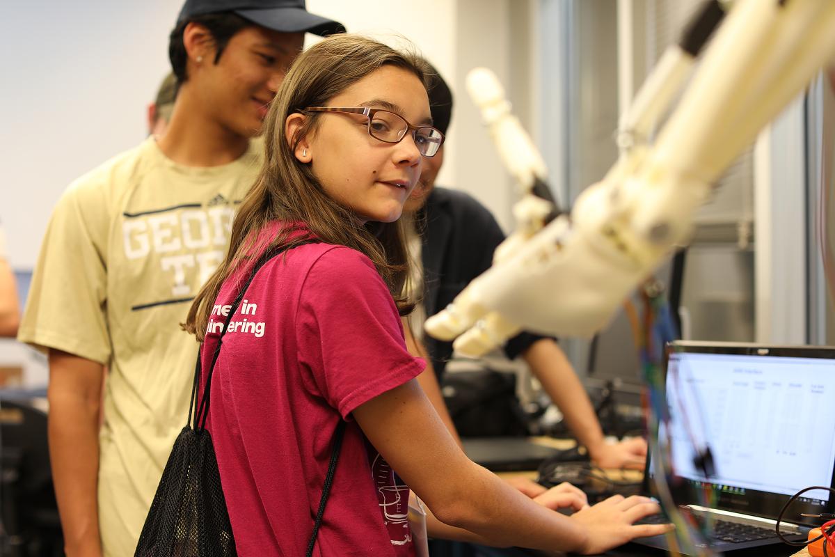 A student operating a robotic arm 