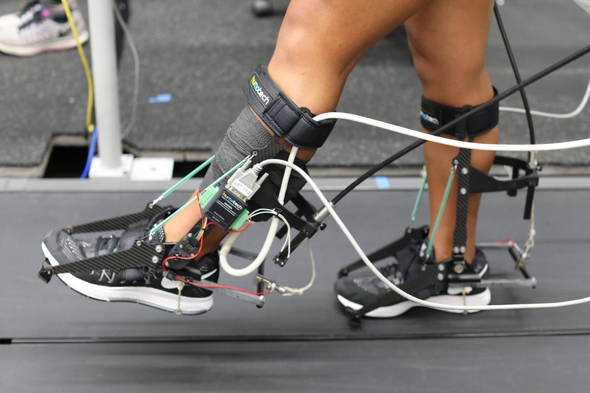 A person on a treadmill wearing robotic devices 