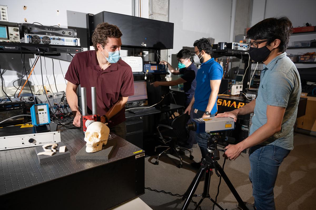 Biomedical engineering grad students in the lab working on a skull vibration test