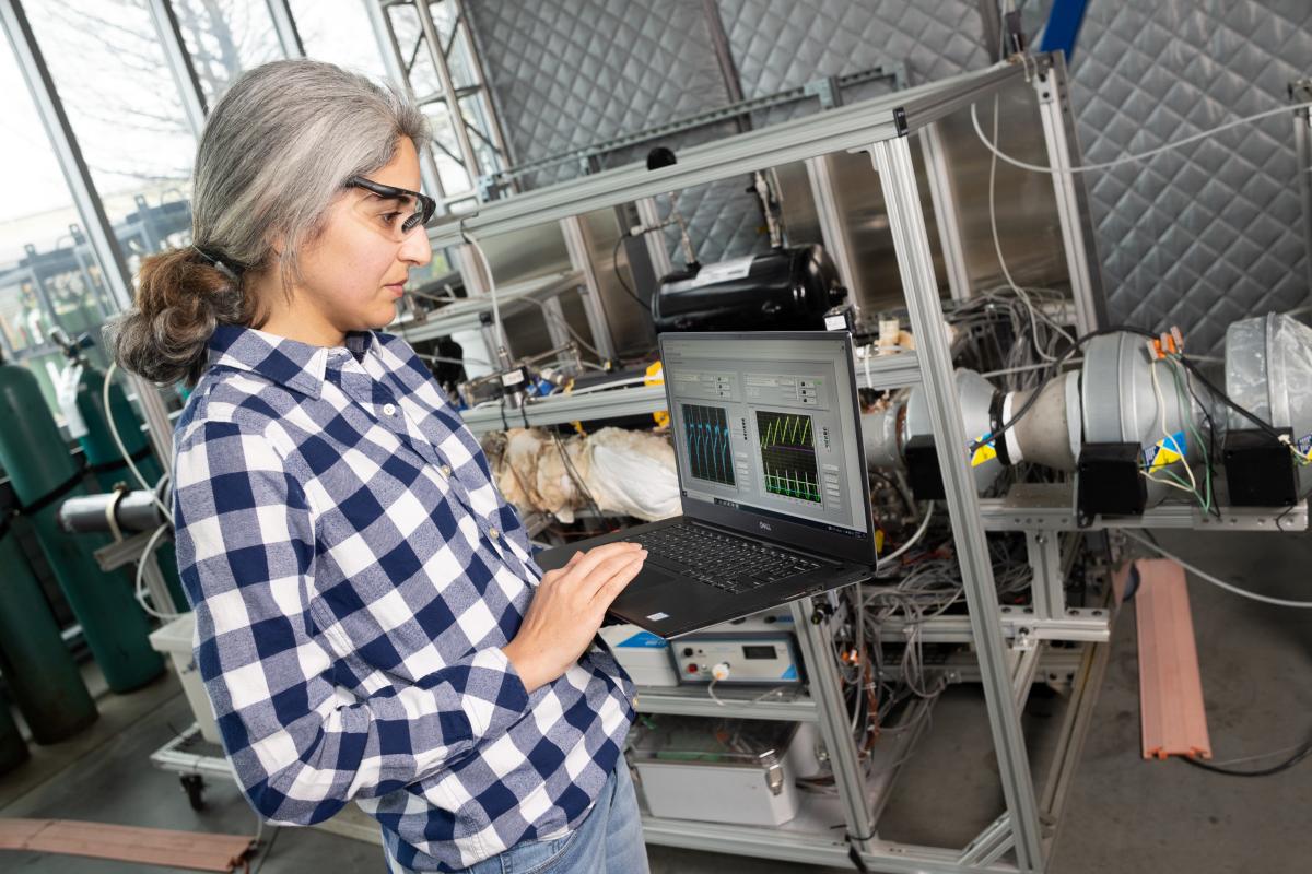 a woman monitors a direct air capture system on a laptop