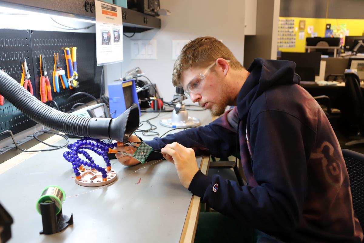 A student works with electronics in the Invention Studio