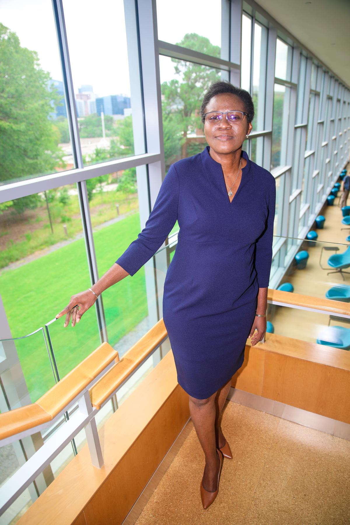 Adjo Amekudzi-Kennedy in the library, standing on the stairs in front of a window