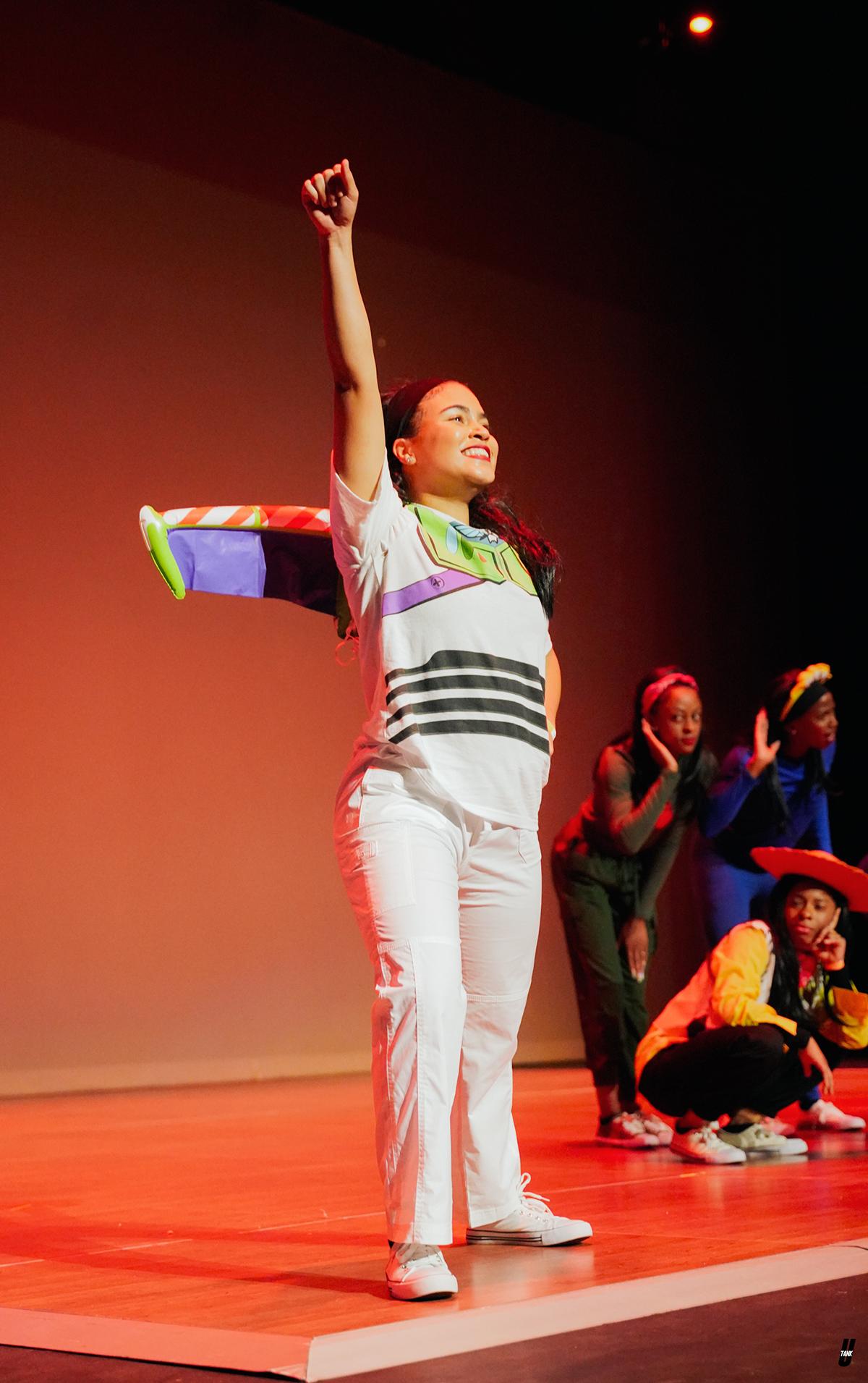 Sydney Mudd on stage dressed in a Buzz Lightyear costume with her arm extended in the air during the NPHC Step Show in Fall 2022.