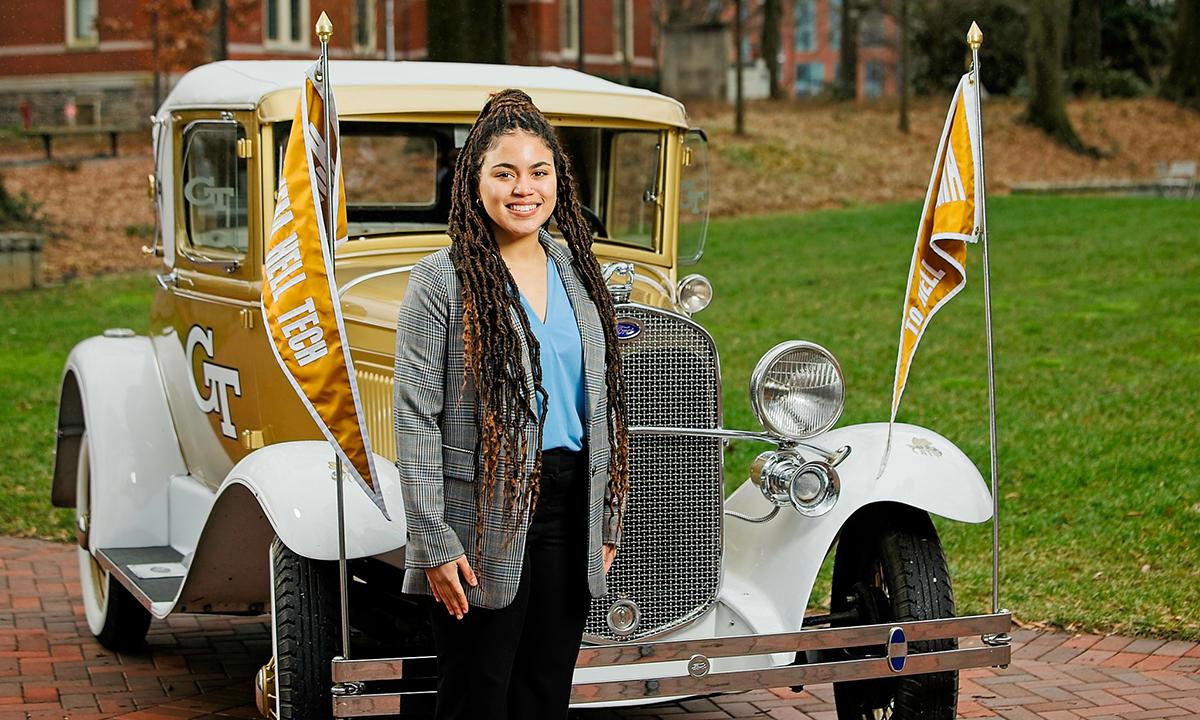 Sydney Mudd poses for a portrait in front of the Ramblin' Wreck.