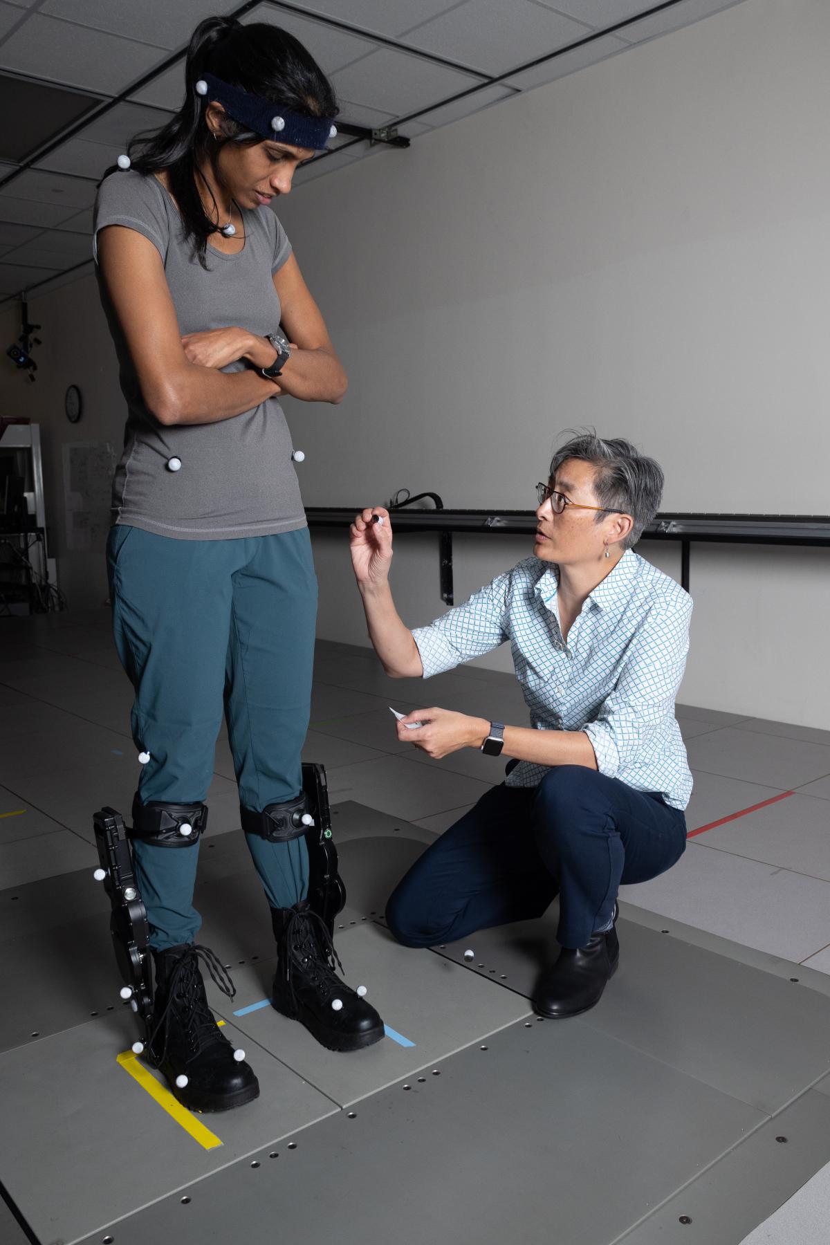 Lena Teng applies sensors to a person standing on a moveable floor platform