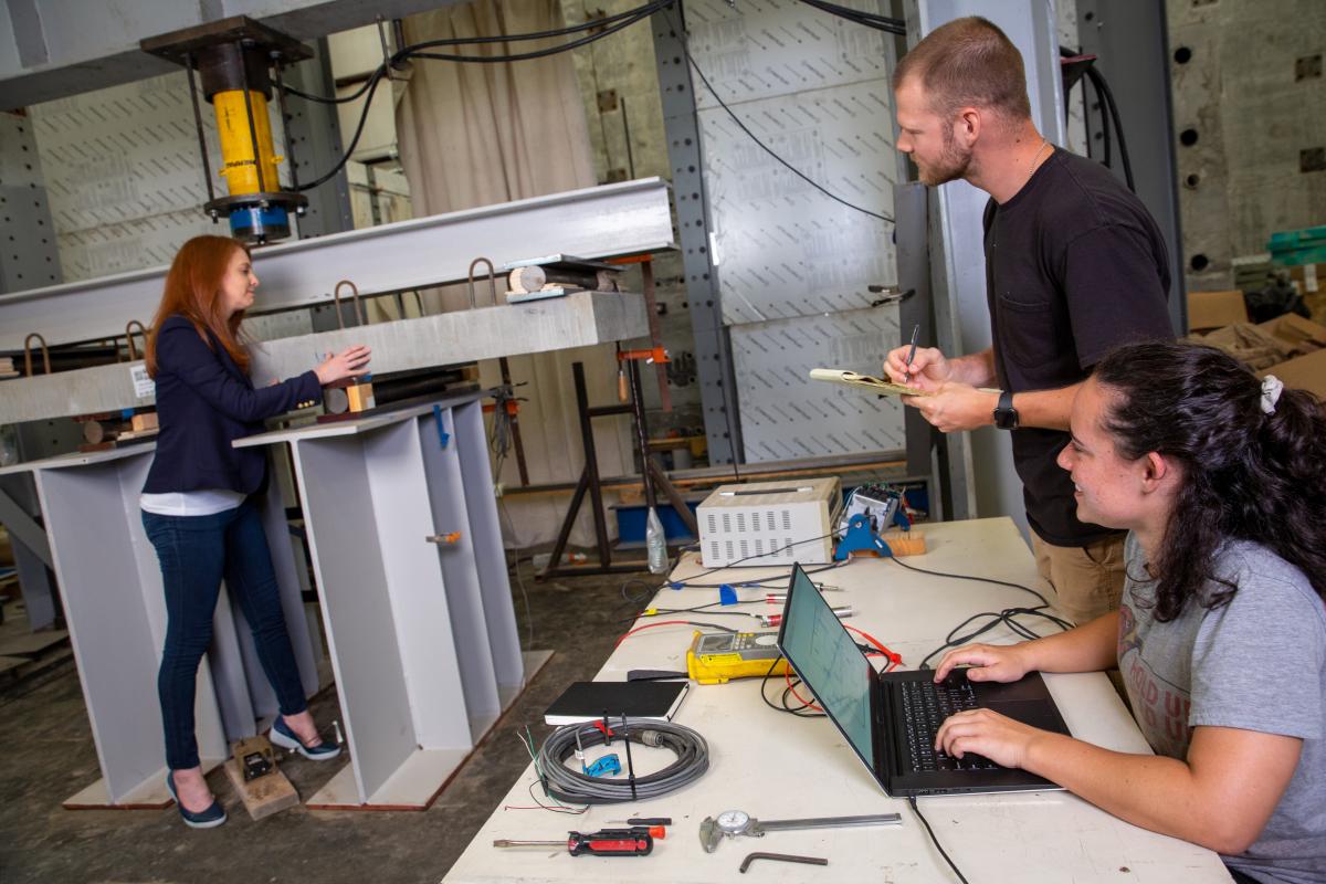 Lauren Stewart works in the lab with two students