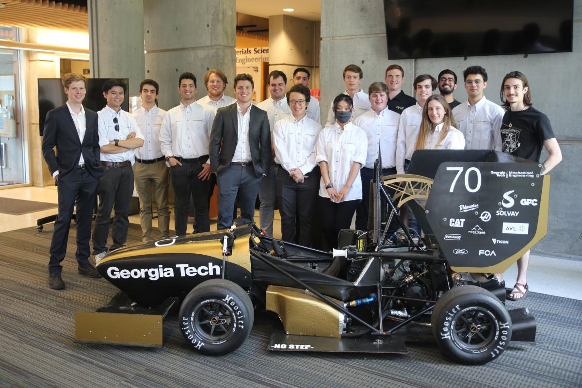 A group of students comprising the GT Motorsports team pose with the 2022 vehicle