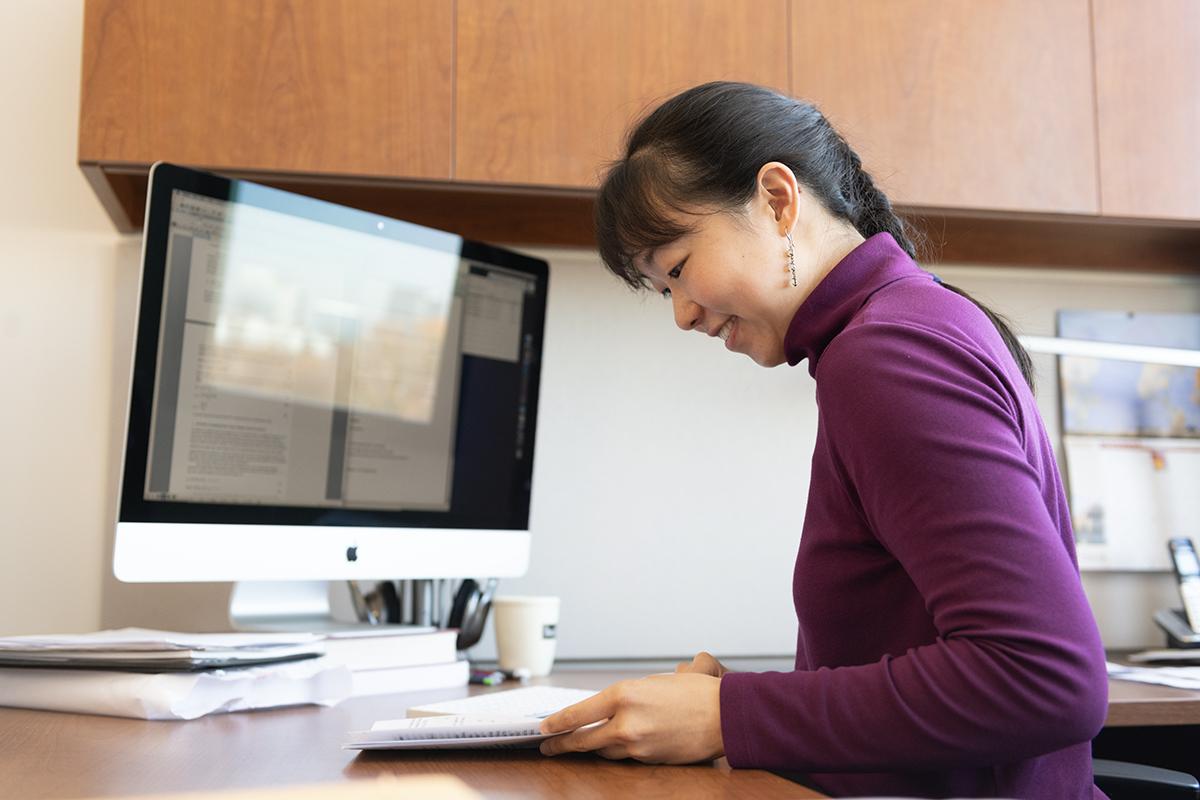 Iris Tien reads papers at her desk.