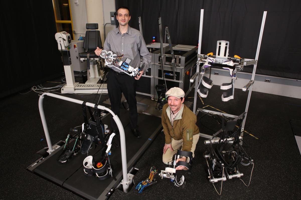 Aaron Young and Greg Sawicki in the lab with a variety of wearable robotic devices