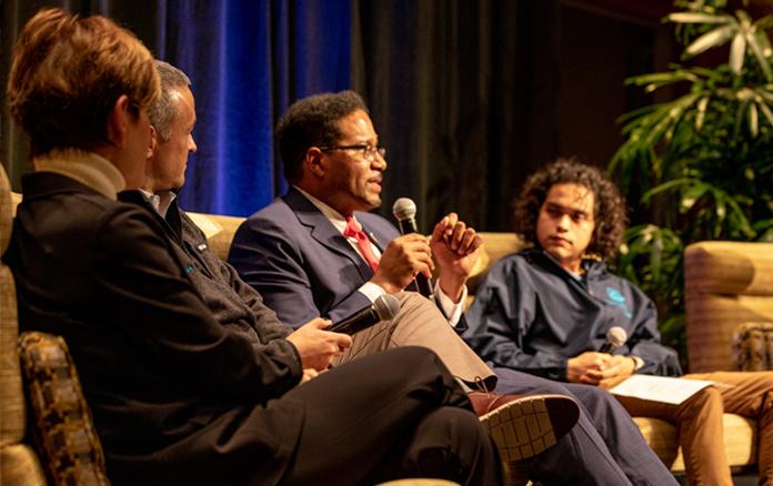 A group of people from the Clark Scholars Program, including Alex Castrejon, listen to a speaker