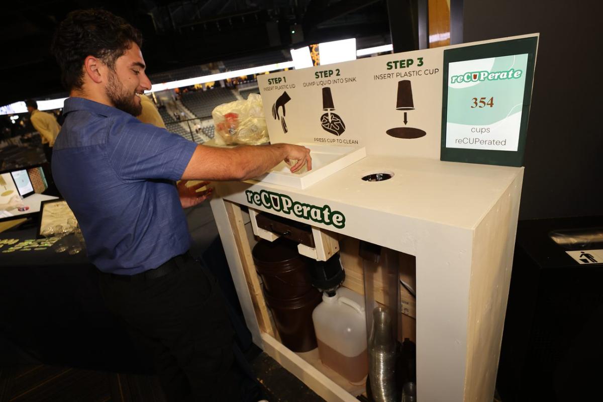 a student demonstrates a cup recycling system